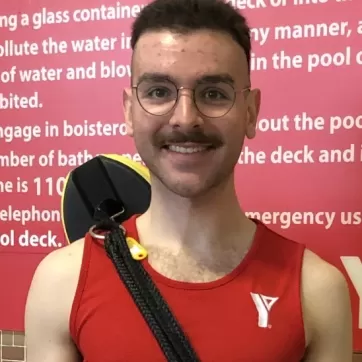 Daniil, a lifeguard at Hamilton Downtown Family YMCA, smiles for a photo.