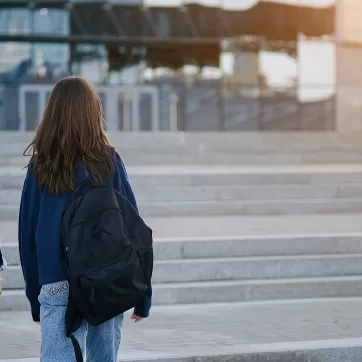 Two young people walking outside with backpacks 