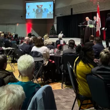 People sitting at tables watching the speaker talk at PeaceMedal