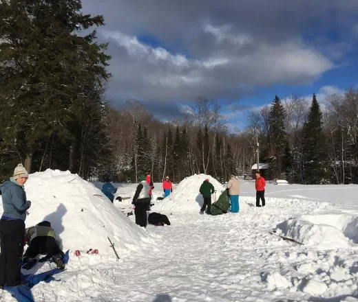 Youth building snow quinzees