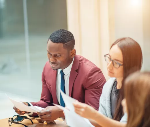 Two young people dressed professionally reviewing paperwork together